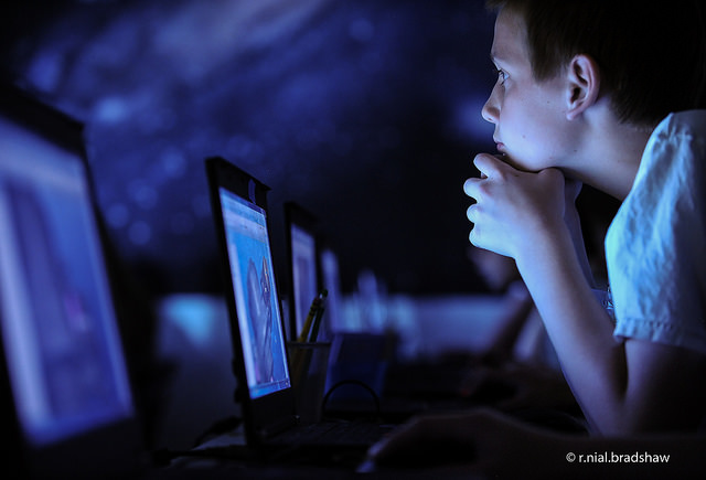 boy looks at computer screen